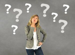 A lady dressed casually with question marks all up in the air.